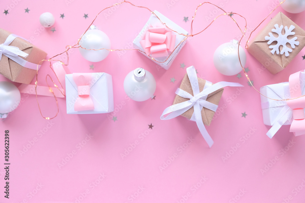 Christmas background with decorations and gift boxes on pink background