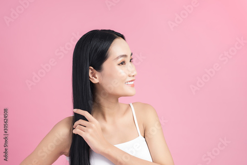 Attractive asian woman taking care of her hair