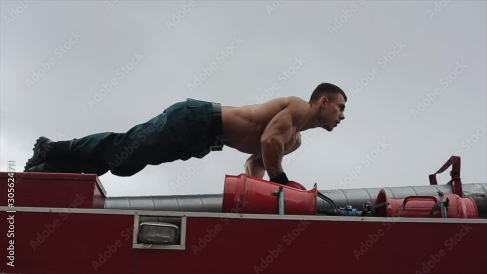 Vidéo Stock Strong man doing push-up on top of fire truck. Close view ...