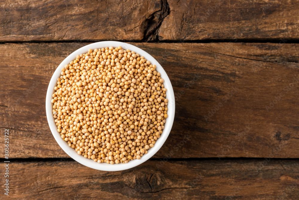 White mustard seeds in bowl on rustic wooden table. Top view White mustard seeds in bowl on rustic wooden table. Top view