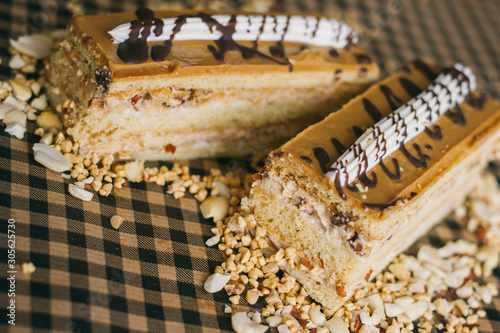 Piece of cake with nuts and caramel on rustic background