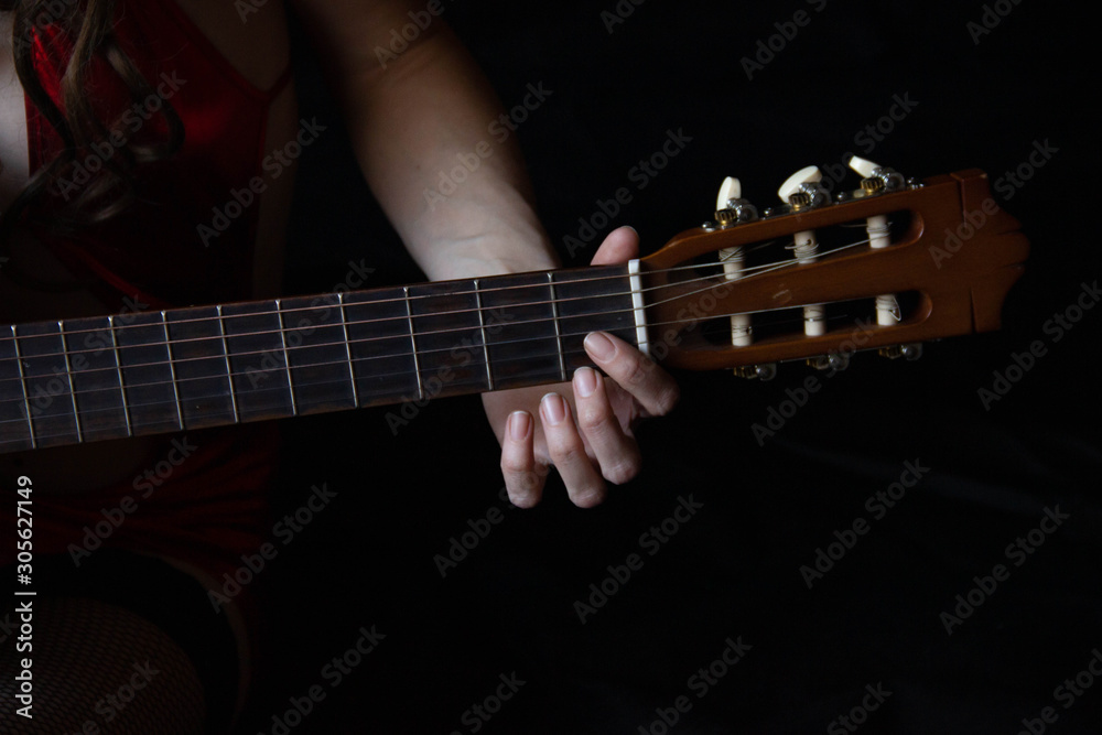 female hands hold an acoustic guitar. play music. female hands hold an acoustic guitar. play music.