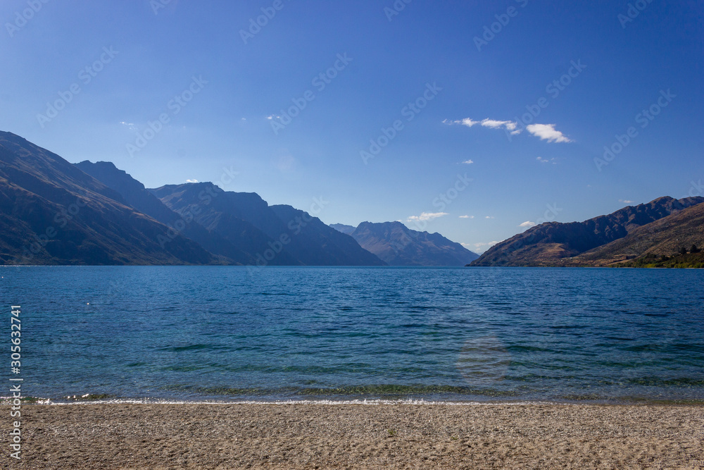 Lake Wakatipu on a free Campground outside of Queenstown with a blue sky, New Zealand