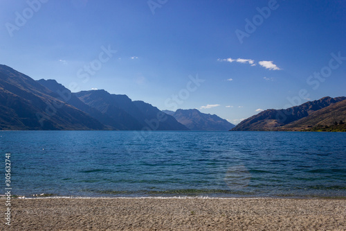 Lake Wakatipu on a free Campground outside of Queenstown with a blue sky, New Zealand