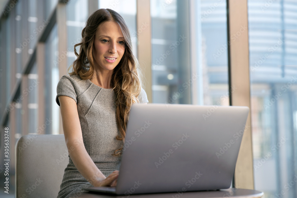 Beautiful global entrepreneur business woman working remotely on a laptop computer, using the internet at the office Beautiful global entrepreneur business woman working remotely on a laptop computer, using the internet at the office