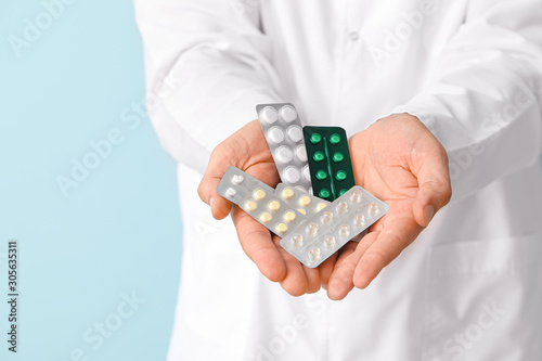 Doctor with medicine on color background, closeup