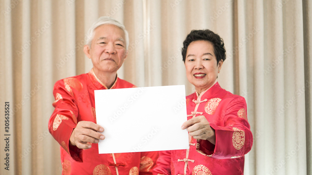 Asian Senior couple holding sign with copy space for Chinese new year surprise good deal Asian Senior couple holding sign with copy space for Chinese new year surprise good deal