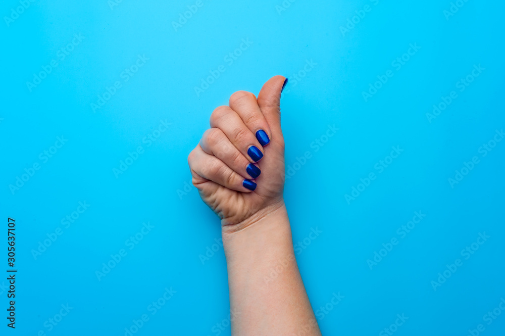 Female hand with dark blue nails showing gesture