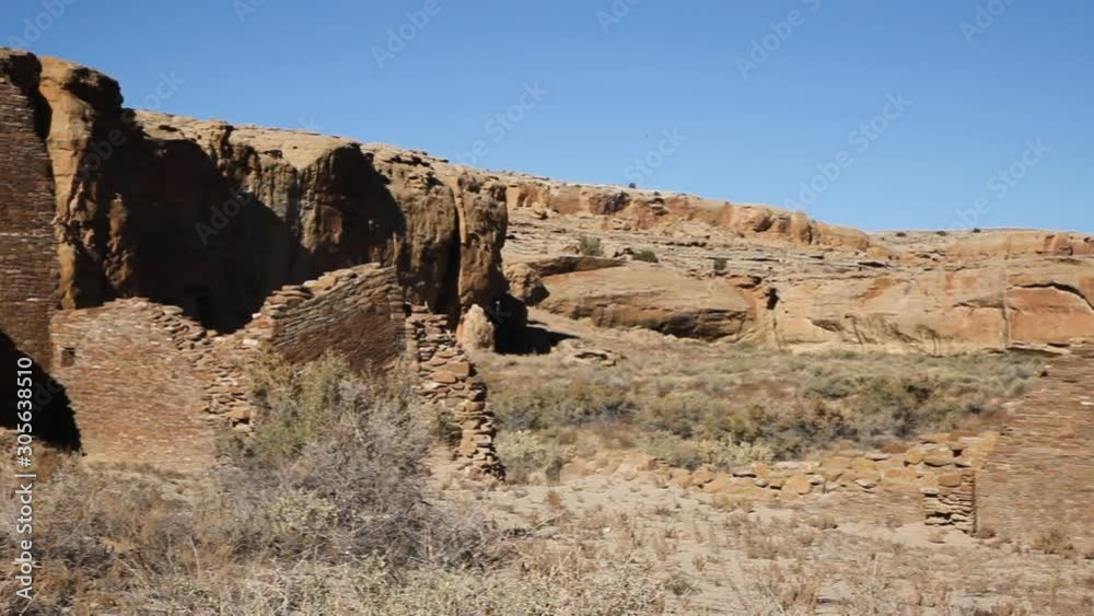 Panning across the ruins of Chetro Ketl in Chaco Canyon, New Mexico. An ancient Anasazi religious site that blends into the surrounding desert landscape. The brick walls are still standing fairly well Panning across the ruins of Chetro Ketl in Chaco Canyon, New Mexico. An ancient Anasazi religious site that blends into the surrounding desert landscape. The brick walls are still standing fairly well