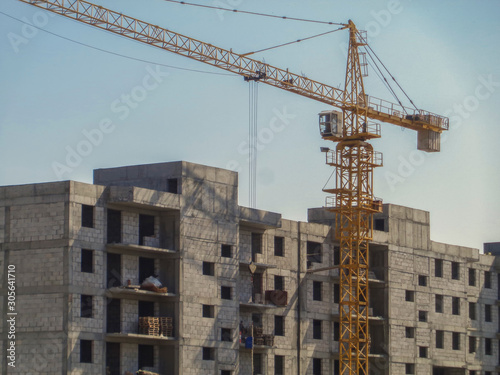 Building under construction. Kazakhstan (Ust-Kamenogorsk). Residential building. Urban grunge. New residential area. Construction site. Construction crane. Blue sky