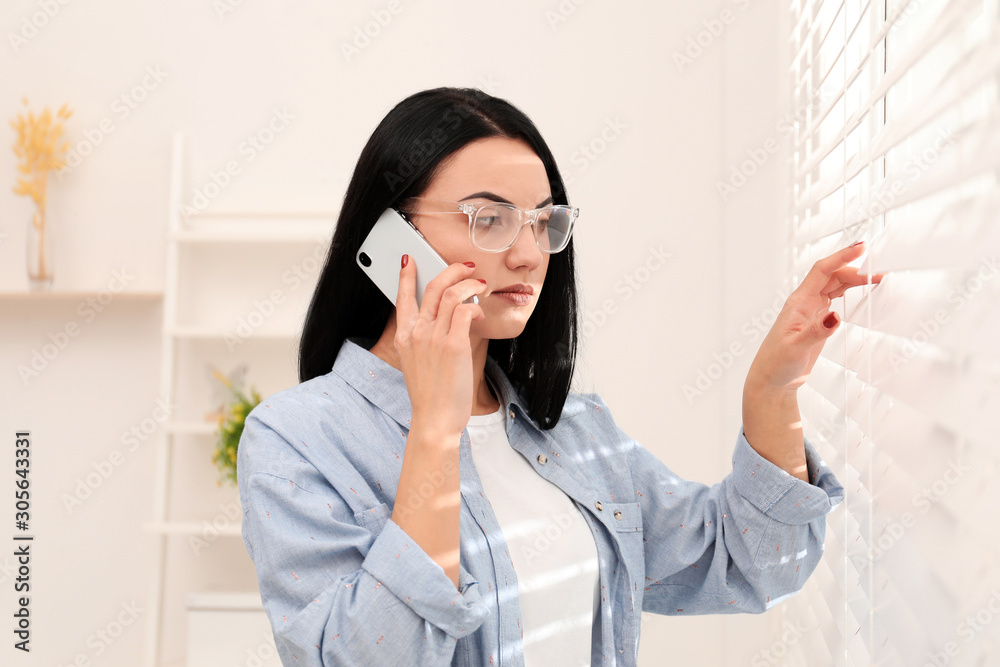 Beautiful young woman talking on phone indoors Beautiful young woman talking on phone indoors