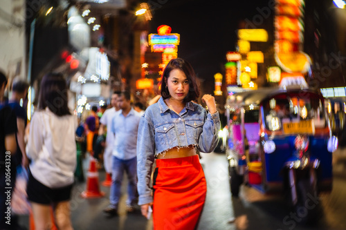 Young Asian fashion stylish traveler woman standing outdoor on street joy city nightlife in China town, Tourist girl travel Bangkok city Thailand, Tourism beautiful destination Asia holiday vacation