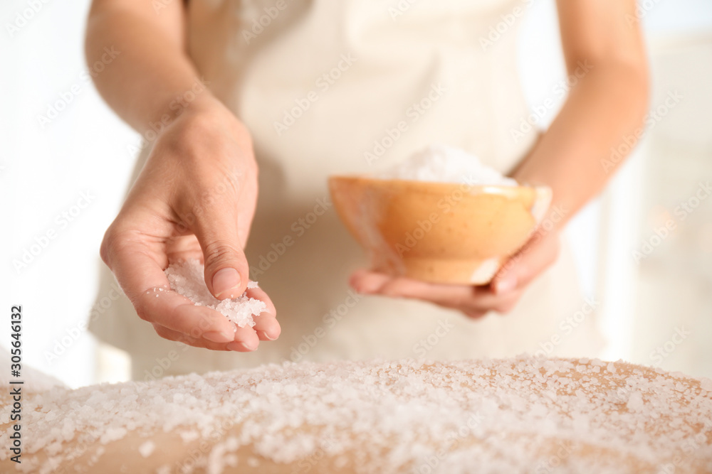 Young woman having body scrubbing procedure with sea salt in spa salon, closeup Young woman having body scrubbing procedure with sea salt in spa salon, closeup