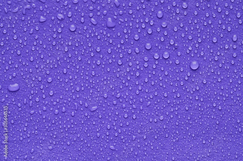 Water drops on lilac background, top view