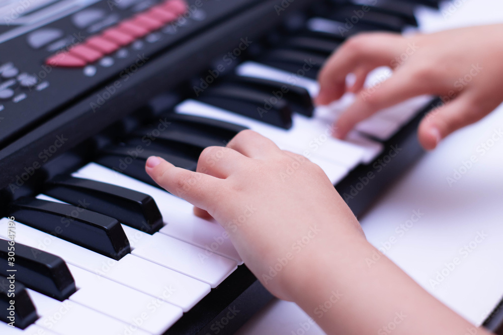 Children's hands play the keys of the piano. Learning music. Children's hands play the keys of the piano. Learning music.