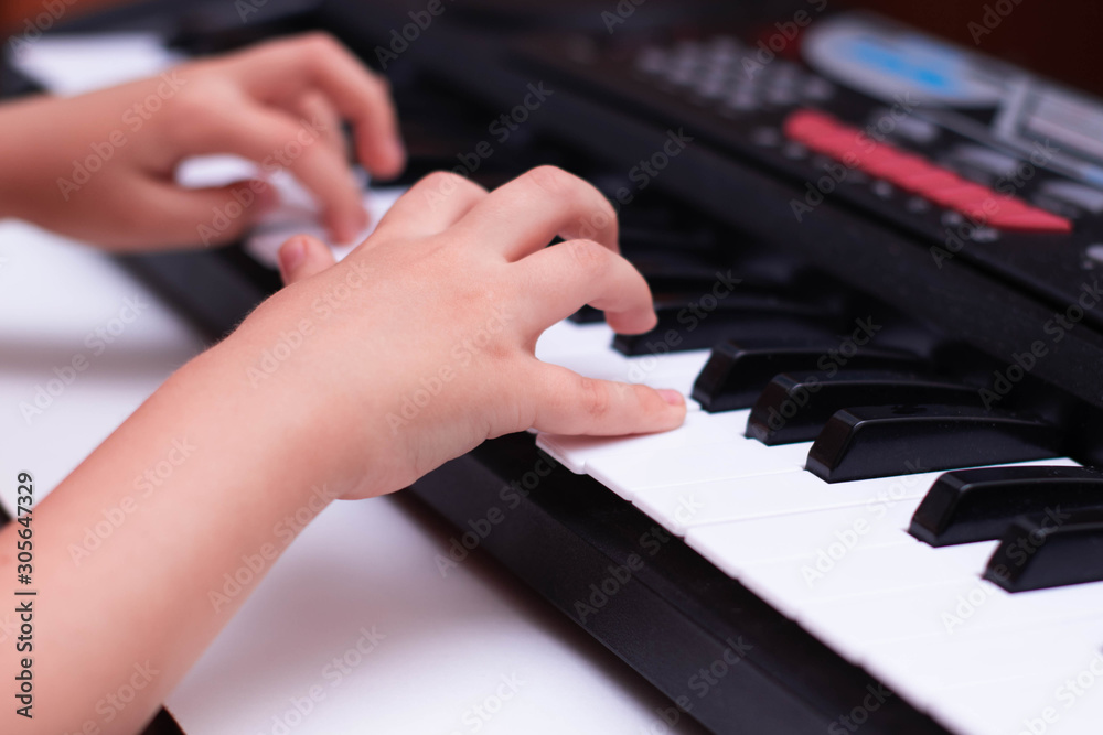 Children's hands play the keys of the piano. Learning music. Children's hands play the keys of the piano. Learning music.