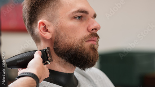 haircut beard typewriter. beard trimmer. Barber services. The man in the barbershop