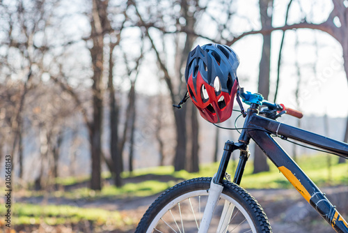 Bicycle with a helmet on the handlebars on a forest path.