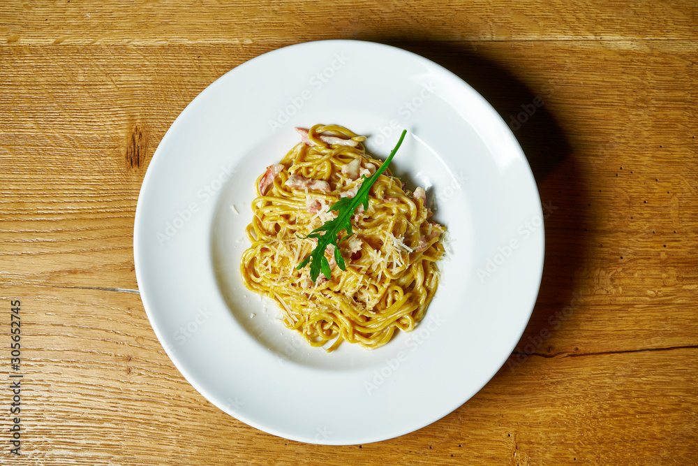Homemade Italian pasta in creamy sauce, bacon and parmesan in a white plate. Italian Cuisine. Close up. Tasty food photo background Homemade Italian pasta in creamy sauce, bacon and parmesan in a white plate. Italian Cuisine. Close up. Tasty food photo background