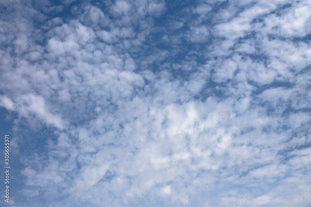 View of a blue sky with a small clouds, different shapes and textured clouds View of a blue sky with a small clouds, different shapes and textured clouds