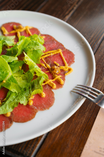 Thinly sliced beef pieces carpaccio served in a cafe