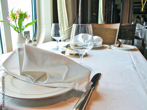 Elegantes Restaurant auf Luxus Kreuzfahrtschiff Ozeanliner Cunard Queen Elizabeth Queen Victoria mit gedeckten Tischen, Kristalllüster und hölzerner Wand in stilvollem Design und Architektur photo