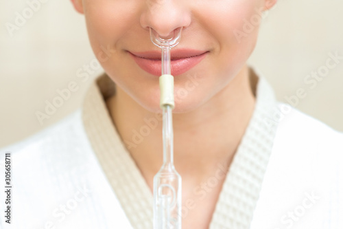 Canvas Print Nasal inhalation for essential oil Maholda in nose of smiling young woman close up