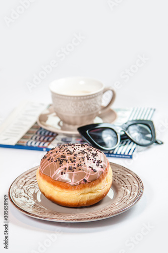 Fresh doughnut with coffee, glasses and fashion magazine