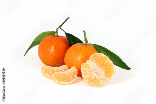 Three fresh clementines with green leaves and juicy slices isolated on white background  