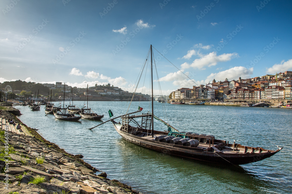 Porto, Portugal old town cityscape on the Douro River with traditional Rabelo boats. 