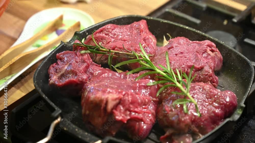 Close-up video of a raw veal steak with spices being prepared in a grill pan Close-up video of a raw veal steak with spices being prepared in a grill pan