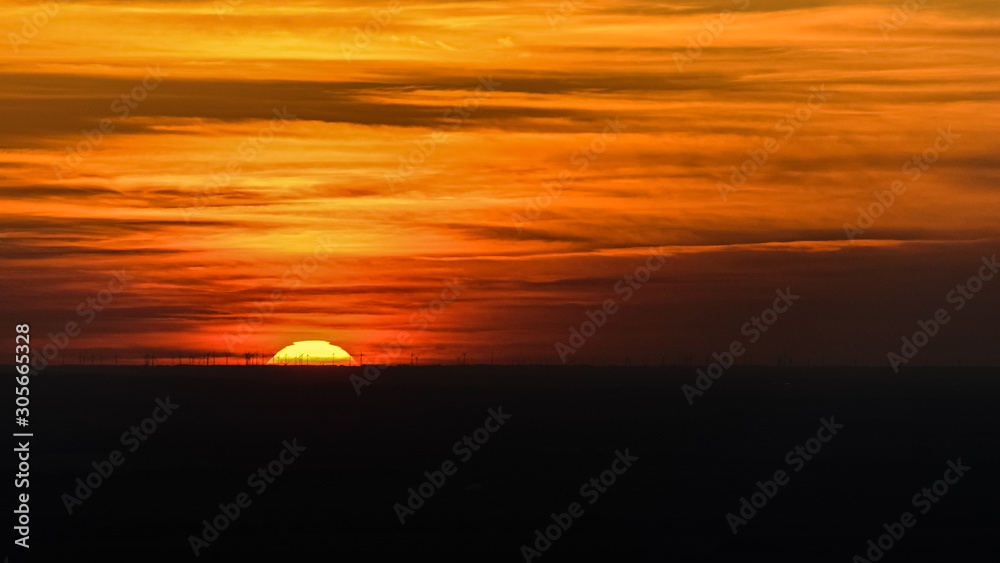 Fototapeta premium Couché de soleil sur champs d'eoliennes