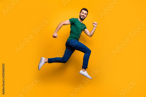 Full size photo of cheerful guy jump run fast for discounts wear modern clothing isolated over yellow color background photo