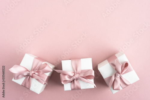 Fototapeta Naklejka Na Ścianę i Meble -  Gift boxes wiyh powdery ribbon. Powdery background. Silver bracelet with charms. Gift box for the New Year and Christmas. Best gift for Valentines Day and Mothers day.