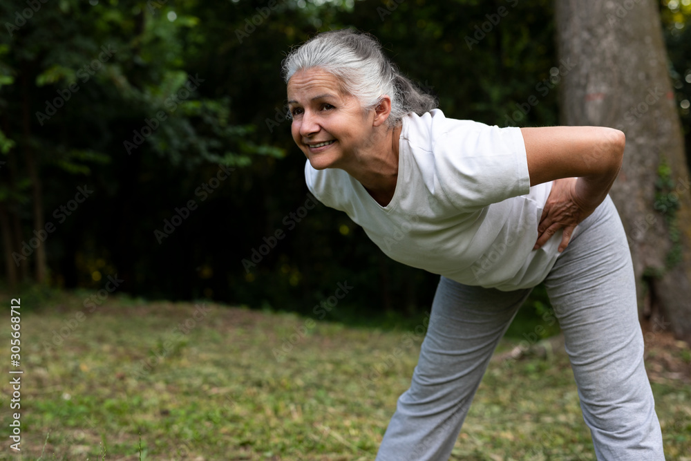Beautiful senior woman is working out in the nature