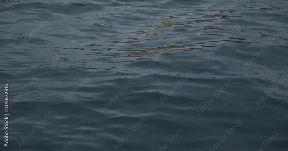 Small waves in a blue water body of water Small waves in a blue water body of water