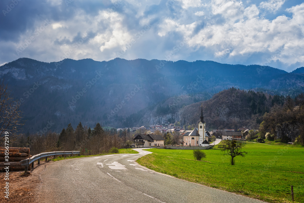 Scenic view of mountain village lit by spring sun in Slovenian Alps