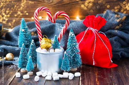 Christmas marshmallows and new year decorations on wood background with grey plaid. Winter holidays