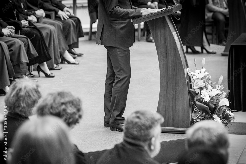 politician in formal suit gives interview. a man in a suit speaks in front of people in black and white. politician in formal suit gives interview. a man in a suit speaks in front of people in black and white.