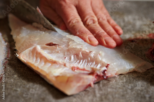 Filleting red sea bream with knife 