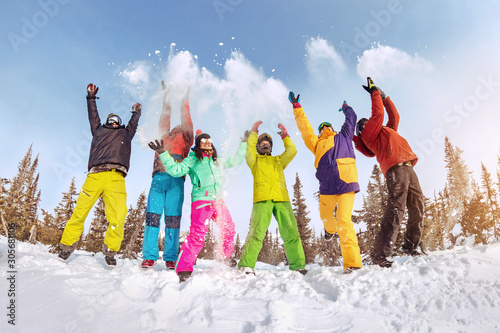 Happy friends skiers and snowboarders having fun