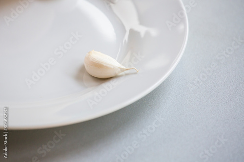 close up of white garlic clove on white