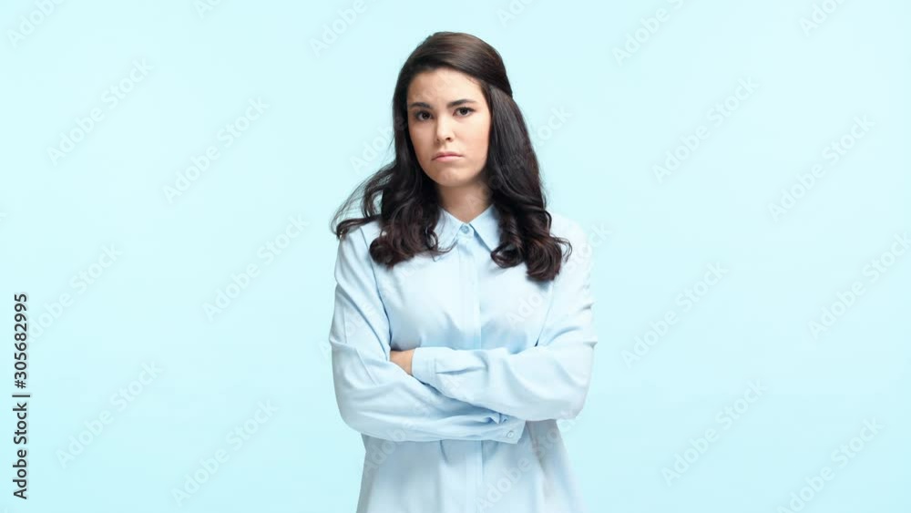 offended girl with crossed arms isolated on blue offended girl with crossed arms isolated on blue