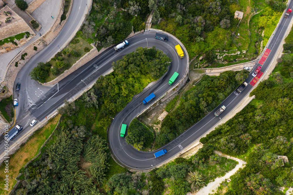 Colorful trucks on the curves road in Mellieha city. Top view. Malta Colorful trucks on the curves road in Mellieha city. Top view. Malta
