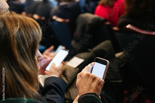 A woman uses the mobile phone in a congress