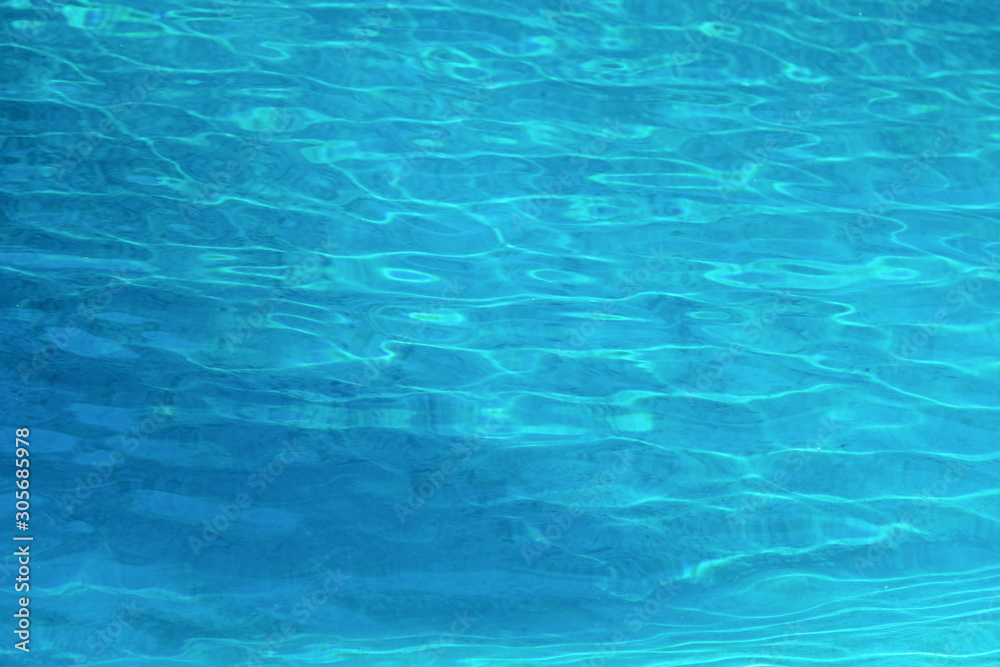 Soft blue wave ripple in swimming pool with sun light reflection on water surface Soft blue wave ripple in swimming pool with sun light reflection on water surface