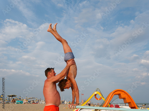 athletic teenager on the beach gymnastic exercises