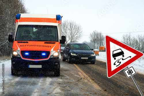 Danger of skidding on slippery road with warning sign. (Rettungswagen-engl. Rescue vehikle) photo