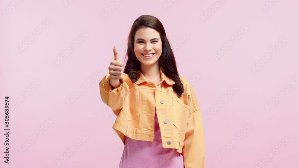 smiling girl showing thumb up isolated on pink smiling girl showing thumb up isolated on pink