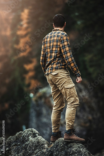 Male traveler standing on top of big rocks in Lago di Braies  Braies lake  Pragser wildsee 